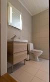 Das zweite Badezimmer im Haus mit Waschbecken, Dusche/WC und Zugang zur Sauna