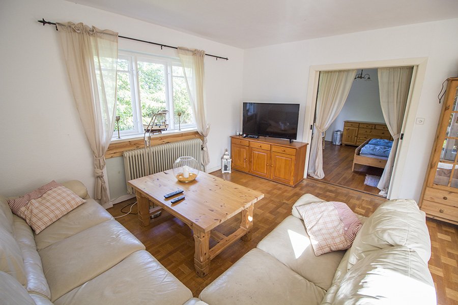 Das gemütliche Wohnzimmer mit Leder-Couchgarnitur, großem Flatscreen und deutschem TV.