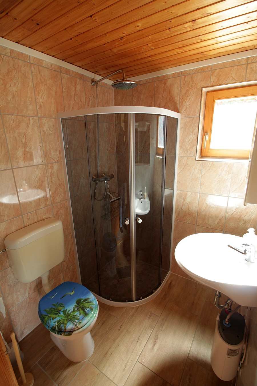 Das Badezimmer mit Dusche, Waschbecken und WC in der Wohnung im Obergeschoß