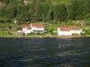 Blick vom Wasser auf das herrliche Grundstück am Fjordufer - links das Ferienhaus Sjursen, im Vordergrund rechts das Bootshaus auf dem eigenen Grundstück, ganz rechts schräg dahinter wohnt ihr Vermieter auf separatem Grundstück