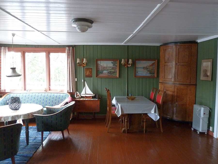 Das Wohnzimmer des Feriehauses ist stilecht mit etlichen Dingen aus den geschichtlichen Etappen des Hauses eingerichtet