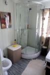 Das Badezimmer des Ferienhauses mit Waschbecken, Dusche und WC