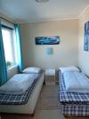 Eines der drei Schlafzimmer mit jeweils 2 Einzelbetten (bei Bedarf jeweils zum Doppelbett zusammenstellbar)
