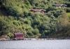 Ferienhaus Lindal (rotes Haus) liegt mit wenigen weiteren Häusern im lockeren Verbund naturnah in erhöhter Lage am Hang - ein phantastischer Weitblick über den Fjord ist hier selbstverständlich. Die Boote liegen hier direkt vor dem Haus am Steg