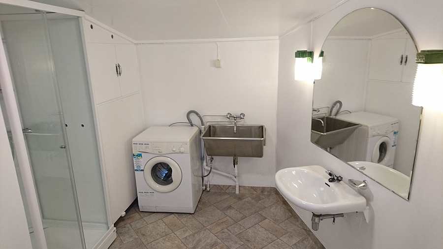 Das Badezimmer des Hauses mit Dusche, WC und Waschmaschine - Fußbodenheizung vorhanden