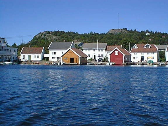 Haus Svinør liegt unmittelbar am Wasser  (weißes Haus zwischen gelbem und rotem Bootshaus)