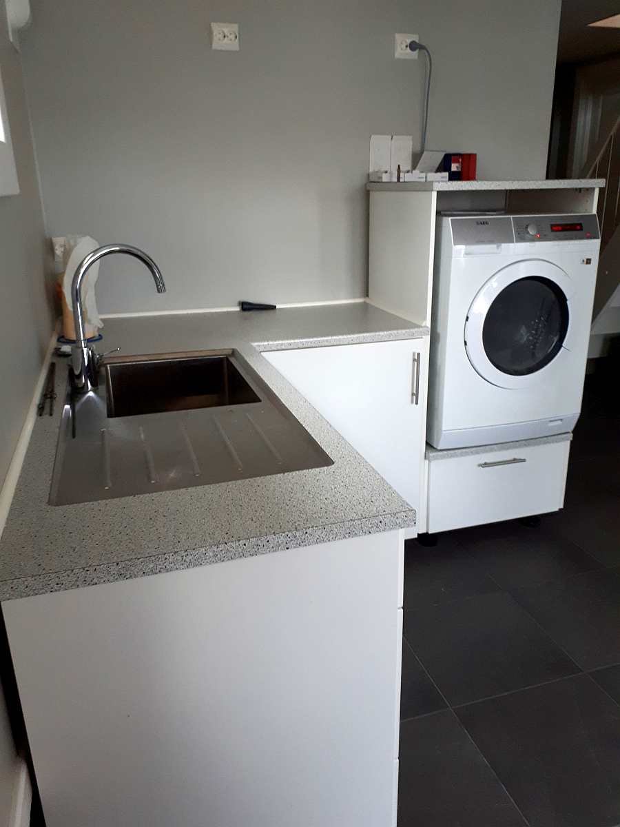 Die Waschküche des Hauses mit Spüle und Waschmaschine Die Waschküche des Hauses mit Spüle und Waschmaschine