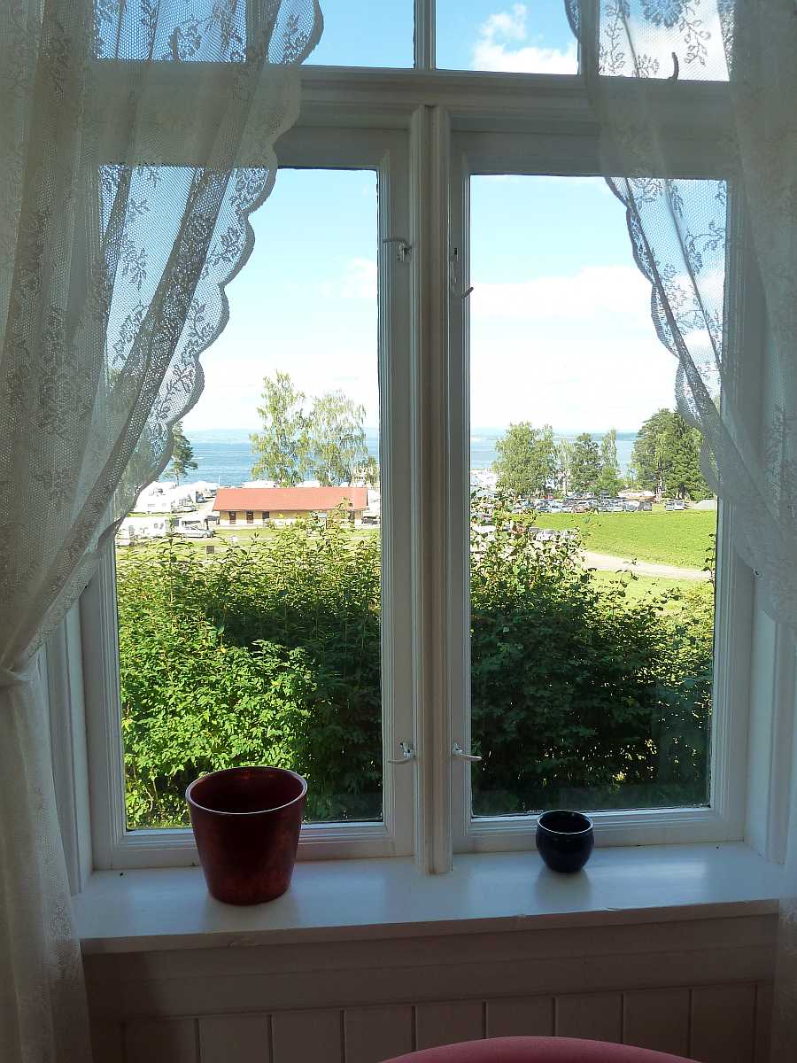 Blick aus dem Wohnbereich zum Seeufer und Bootshafen