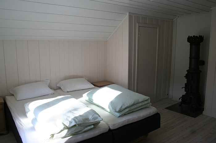 Schlafzimmer mit Doppelbett (auch als Einzelbetten nutzbar) und gemütlichem Holzofen Schlafzimmer mit Doppelbett (auch als Einzelbetten nutzbar) und gemütlichem Holzofen