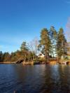 Blick vom Wasser auf das große Naturgrundstück des Hauses. Rechts der eigene Bootssteg