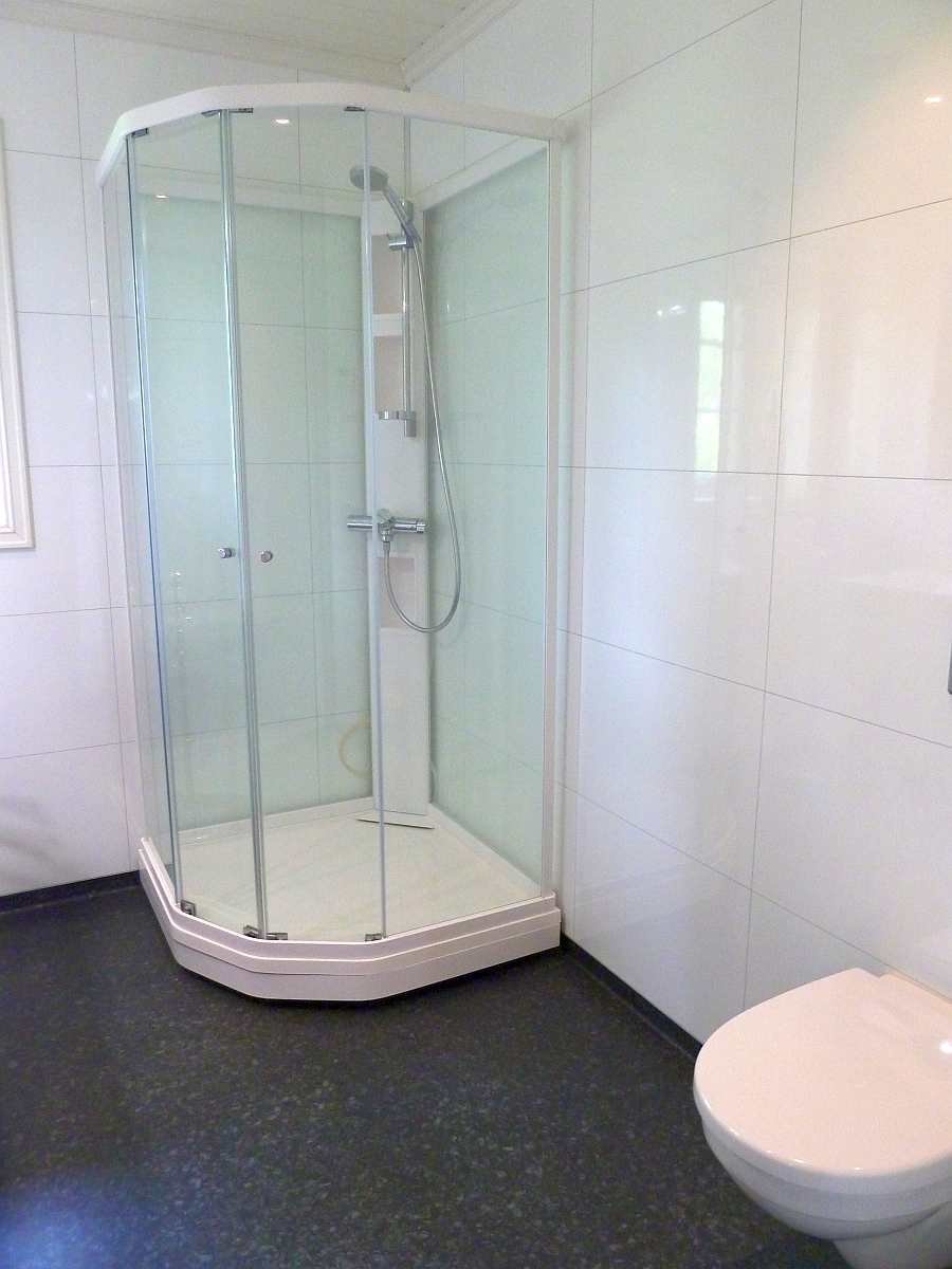 Das Badezimmer ist hell und modern. Es ist mit einer Fußbodenheizung ausgestattet