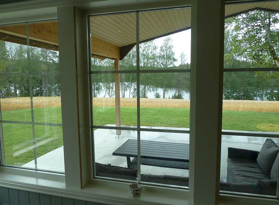 Blick vom Wohnbereich auf die Terrasse und den See