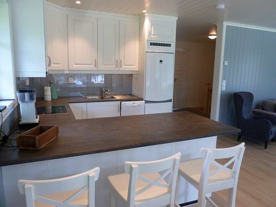 Ein Küchentresen mit Barhockern trennt die offene Küche vom Wohnbereich ab.