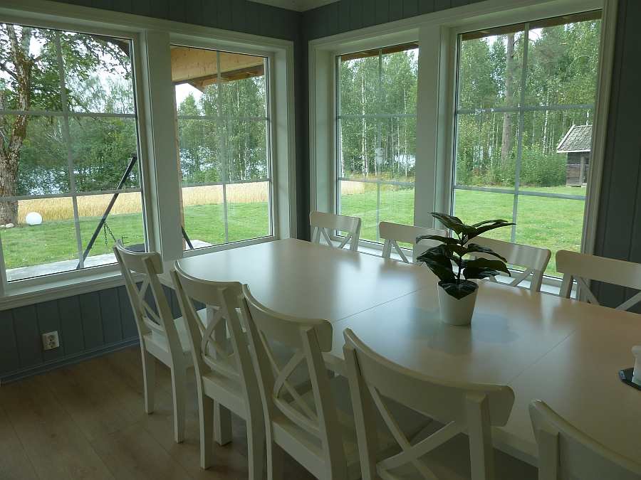 Auch vom Esstisch kann man durch die großen Fenster direkt in den eigenen Garten und auf den See schauen