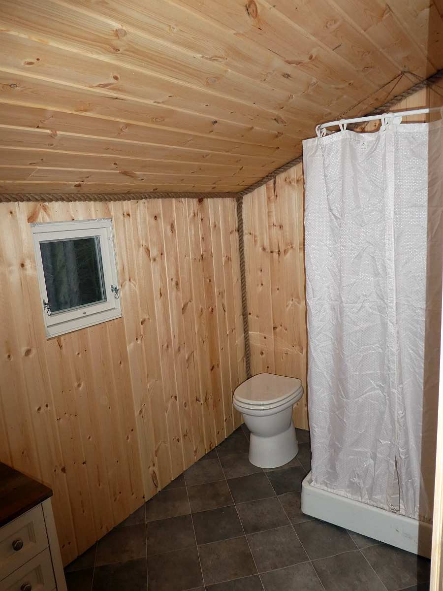 Das Badezimmer des Hauses mit Waschbecken, Dusche und moderner Biotoilette