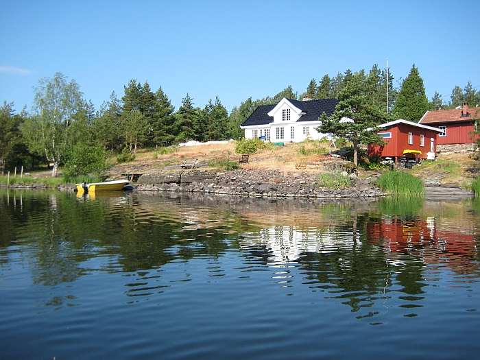 Die Ferienhäuser Tangen am Steinsfjord. Typ 2 im Vordergrund (rot), Typ 1 dahinter (rot). Im weißen Haus wohnt Ihr Vermieter